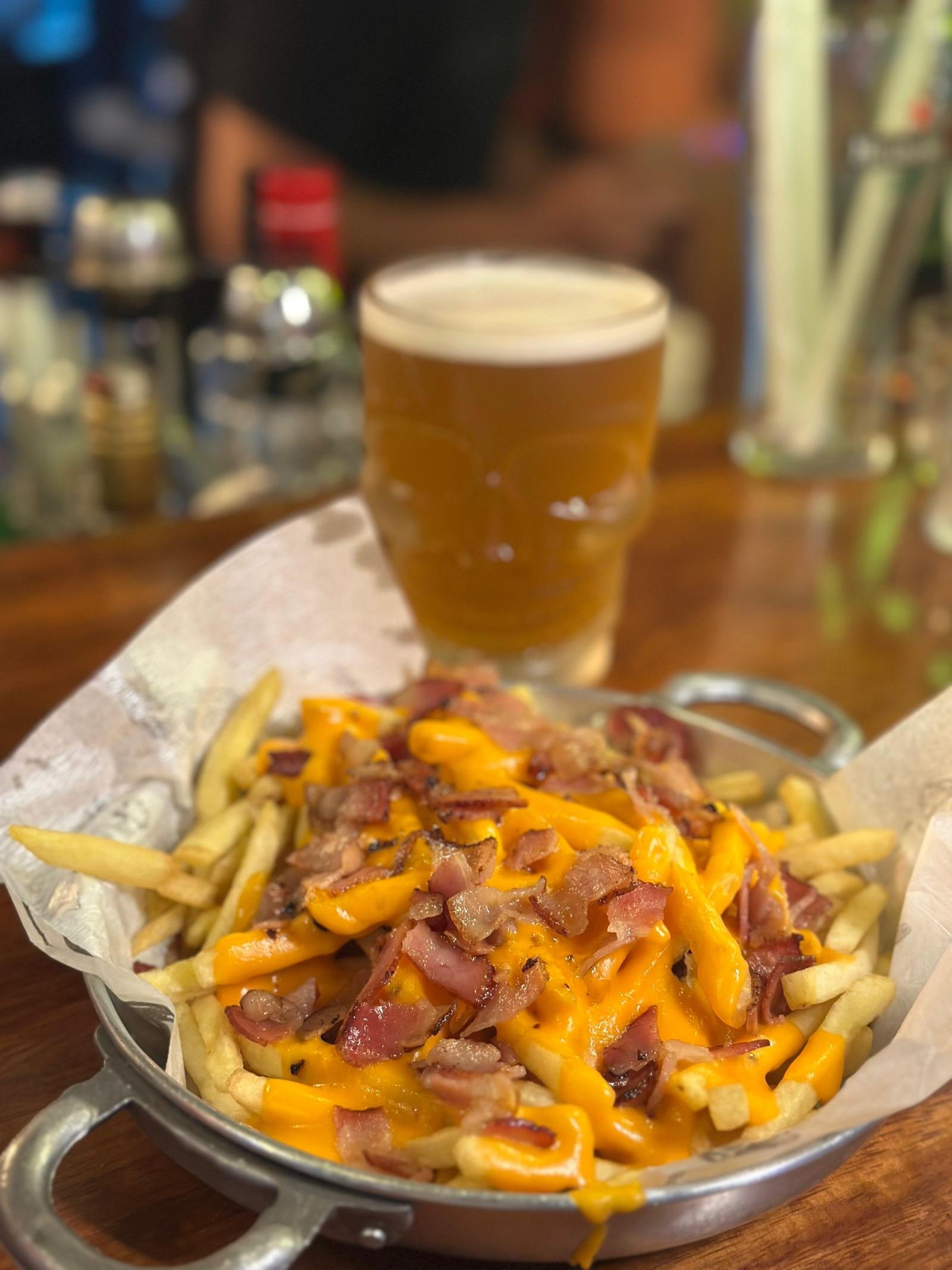Papas con cheddar y panceta junto a una cerveza en el Beer Rock Pub en Porto de Galinhas